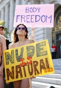 A woman, who would not give her name, holds a sign saying "Nude is Natural," during a rally against banning nudity in parts of the city in San Francisco, California, November 14, 2012. REUTERS/Beck Diefenbach (UNITED STATES - Tags: CIVIL UNREST POLITICS SOCIETY)