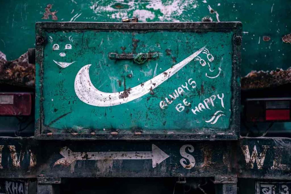 Graffiti of a Nike sign with “Always be happy” written below