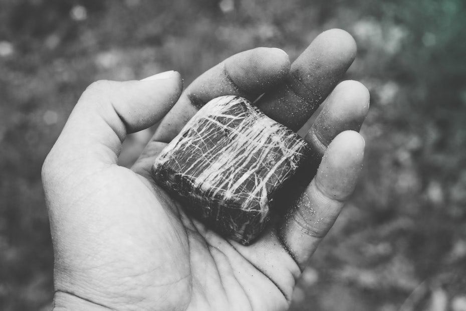 Hand holding a piece of rock.