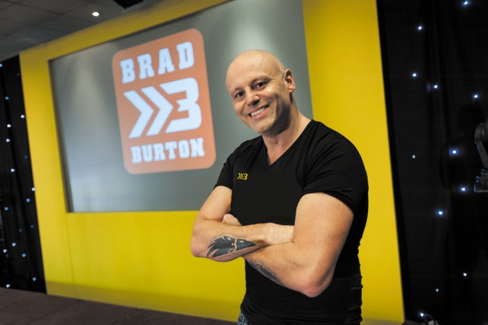 Brad Burton in black shirt in front of logo