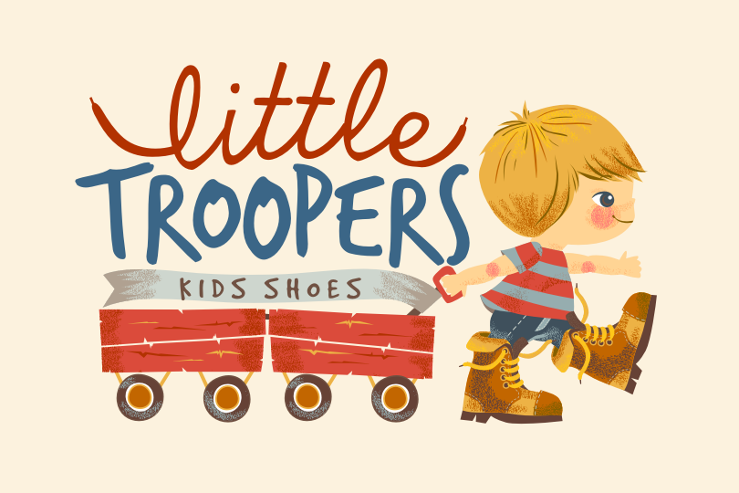 Little boy in boots pulling two wagons with the text “Little Troopers kids shoes”