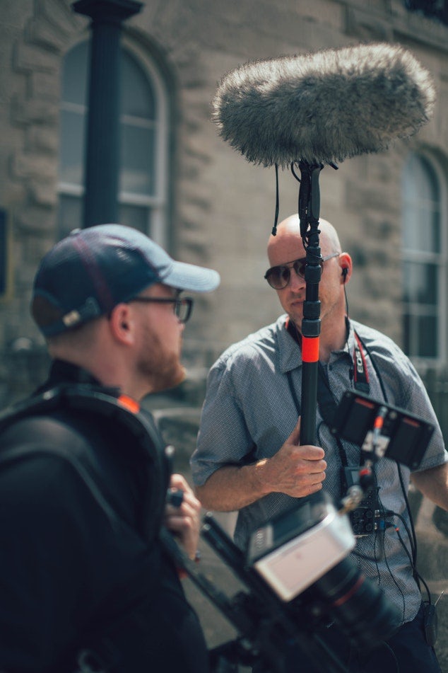 Sound recordist and camera operator discuss the next shot