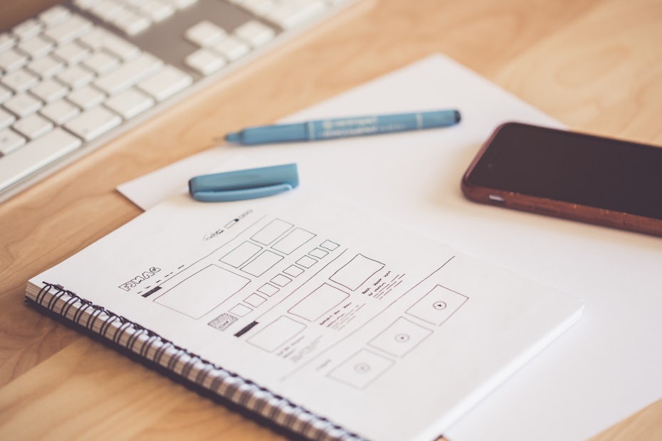 wireframe on notebook with pen and phone