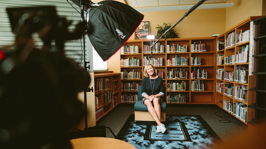 A video production of a person being interviewed in a library
