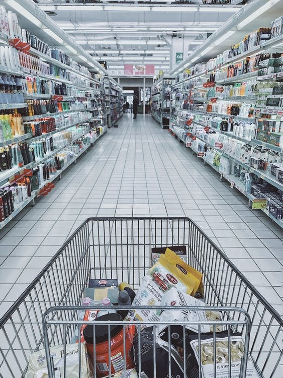 Grocery cart in between store shelves