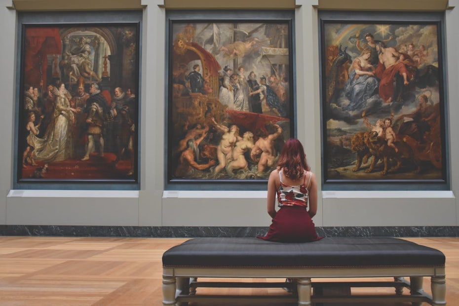 Women sitting in front of paintings at an art museum