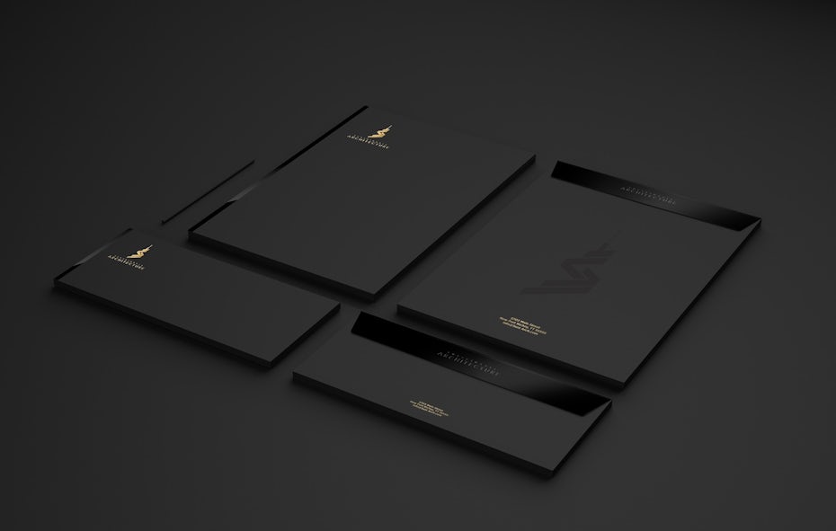 black and white stationary with an embossed logo and a gold corner logo