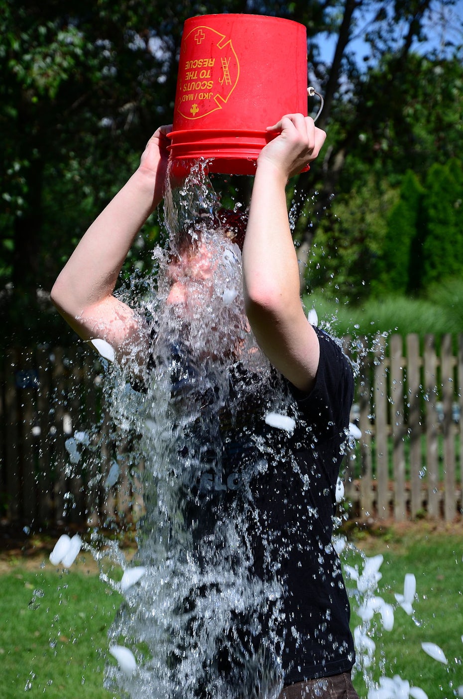 homem despejando gelo de um balde vermelho na cabeça