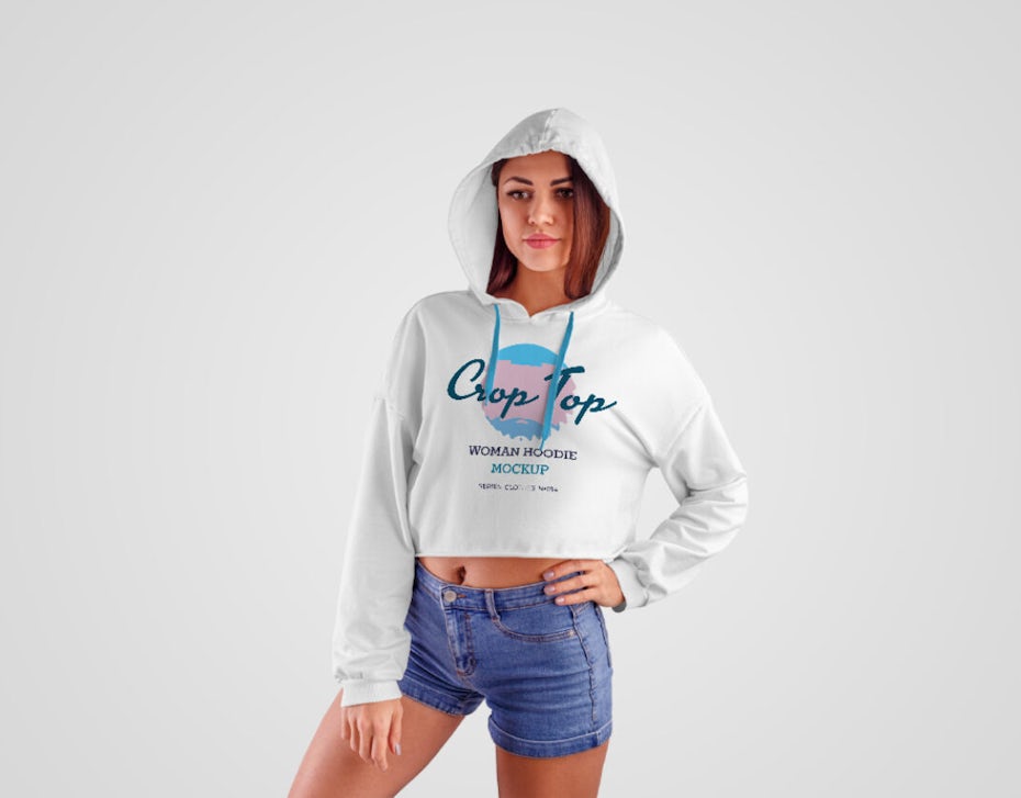 teenage girl wearing hoodie with a logo on it, standing with her hand on her hip