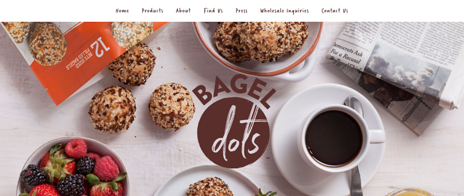 Bagels dots on a table with coffee and a bowl of fruit