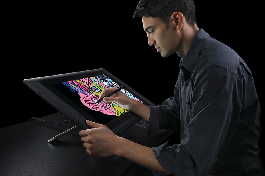 Un hombre sentado frente a una Wacom Cintiq 22, dibujando