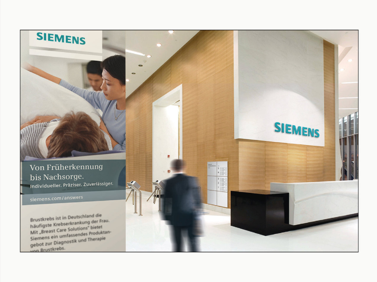 a building lobby showing a reception area with the Siemens old logo on a large white panel