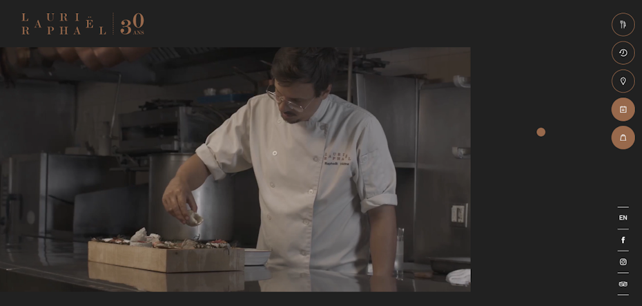 Un chef sostiene una concha marina sobre una bandeja de mariscos.