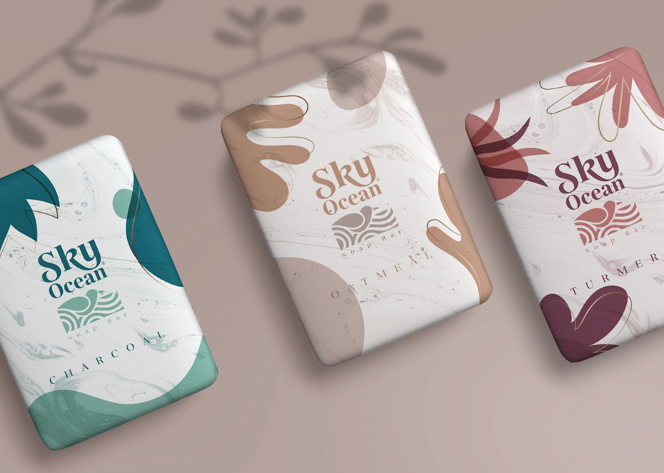three soap wrappers, each in a different color, with organic shapes in different colors