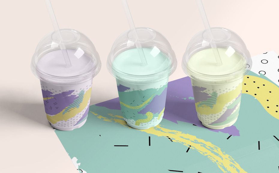 Drei pastellfarbene Bubble Milks in Plastikbechern mit Memphis-Motiven an den Becherseiten