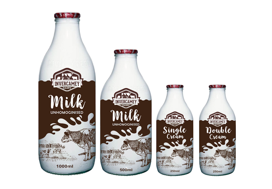 four glass milk bottles with brown imagery and text on the label