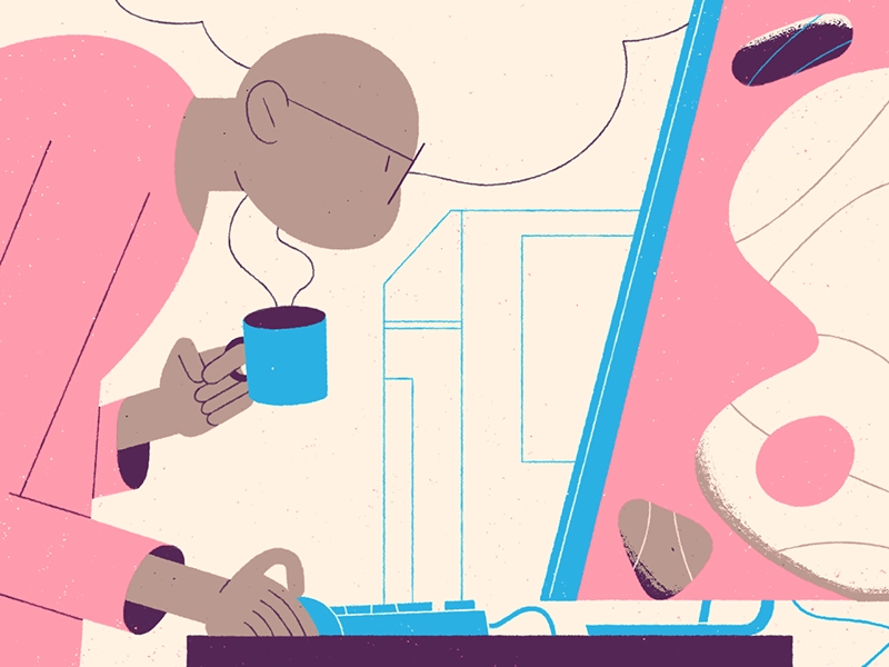 A bald man holding a cup of coffee and wearing a pink jumper crouches down to read his emails