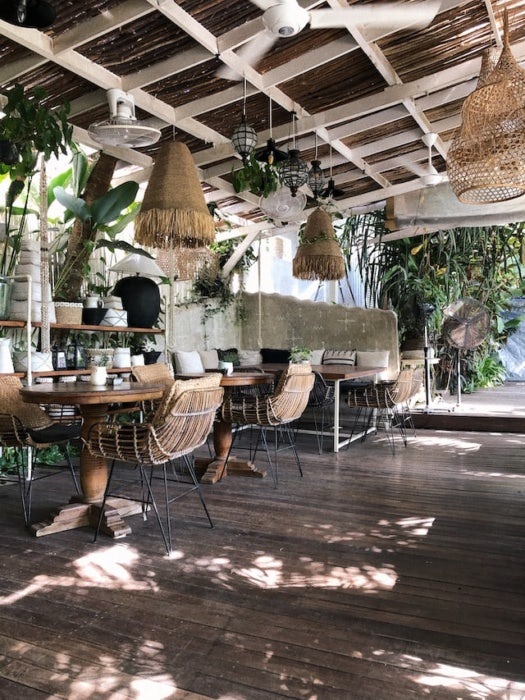 photograph of a co-working space in Bali with tables, chairs and ceiling fans