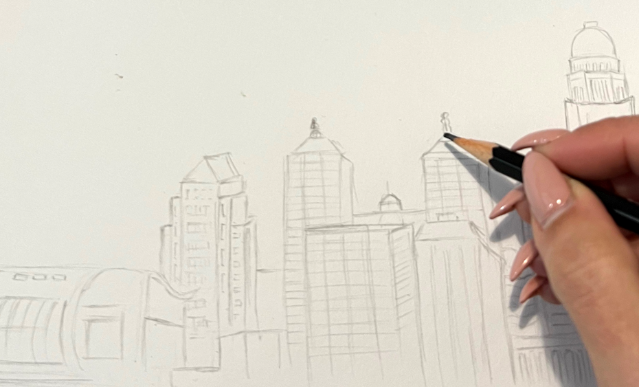 a person sketching buildings with a pencil