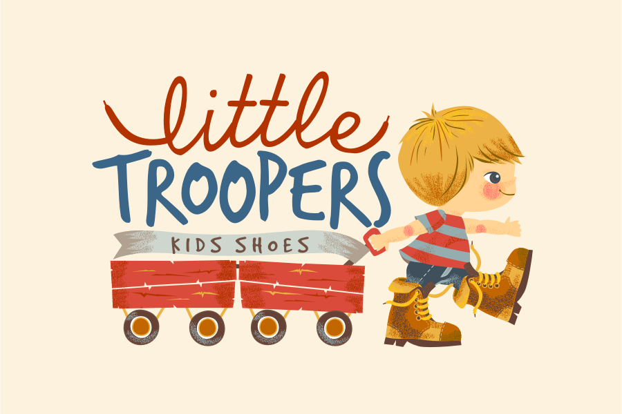 Little boy in boots pulling two wagons with the text “Little Troopers kids shoes”